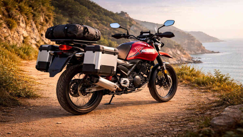 Rear view of Hero Xpulse 160 in red touring setup on a coastal dirt road, 16:9 realistic shot.
