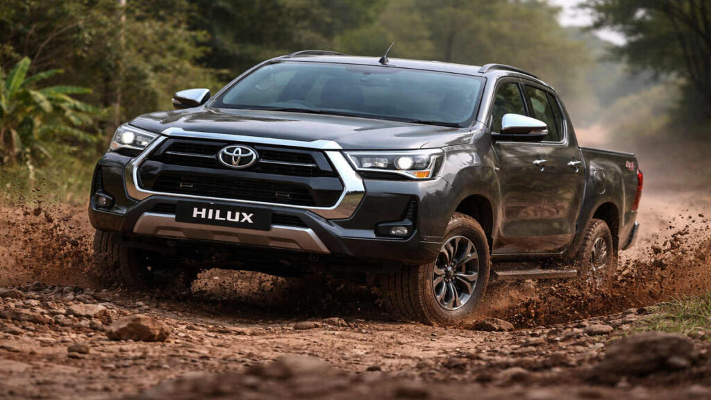 Toyota Hilux Grey Metallic driving off-road on rough terrain in 16:9 realistic shot